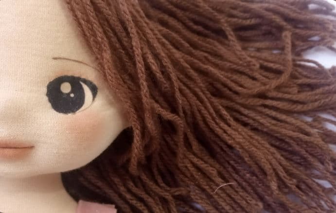 Selfe de rosto de boneca de pano morena com cabelo de fio de lã