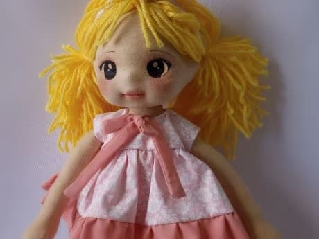 Selfie de boneca de pano loira com vestido rosa